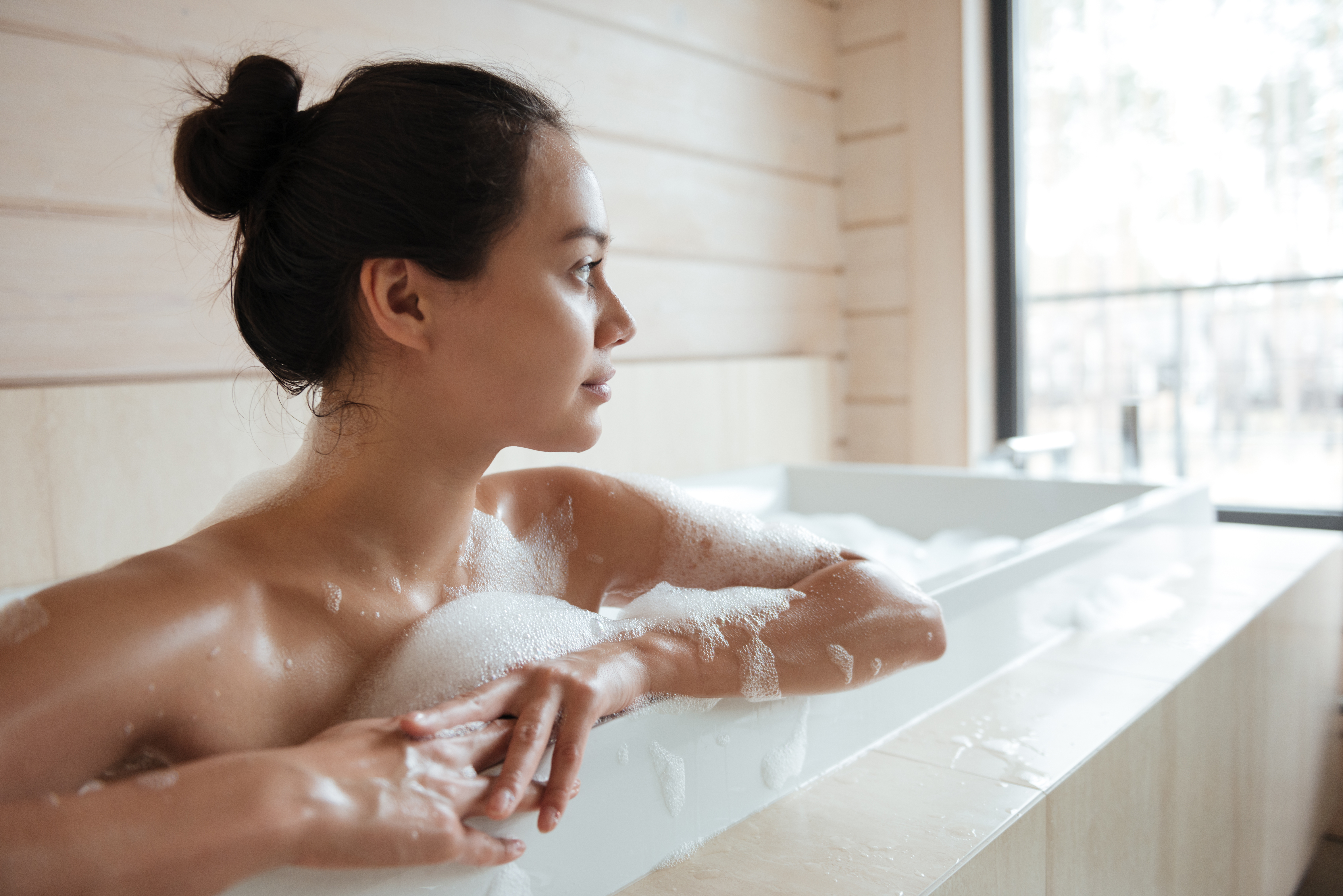 Woman Resting In Bubble Bathtub At Home